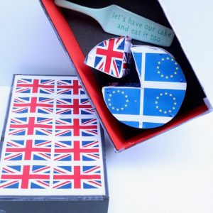 British flags stuck on a piece of paper and a cardboard box. Another art piece is made to look like a piece of cake, with the EU flags on one side and the British flag on another