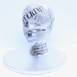 Newspaper stuck together on a mannequin's head