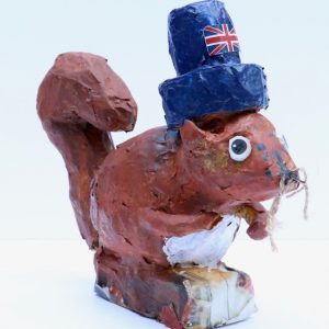Paper Mache squirrel with a blue hat on, painted in the colours of a red squirrel, and a British flag stuck on the hat